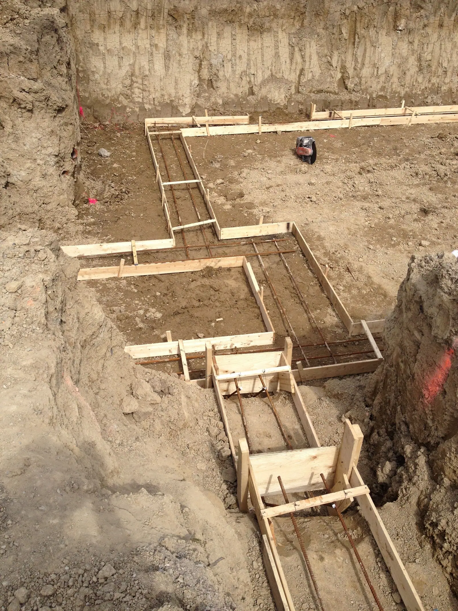 Timber forms laid out in the excavation to shape the footings.