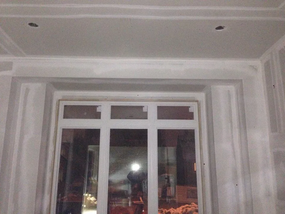 A window opening with French doors, wrapped in unpainted trim.