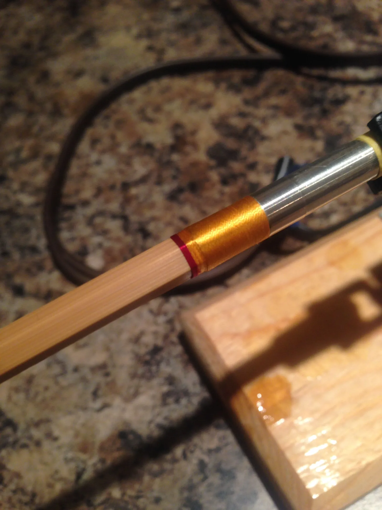 The wrap and ferrule of a bamboo rod on a counter.