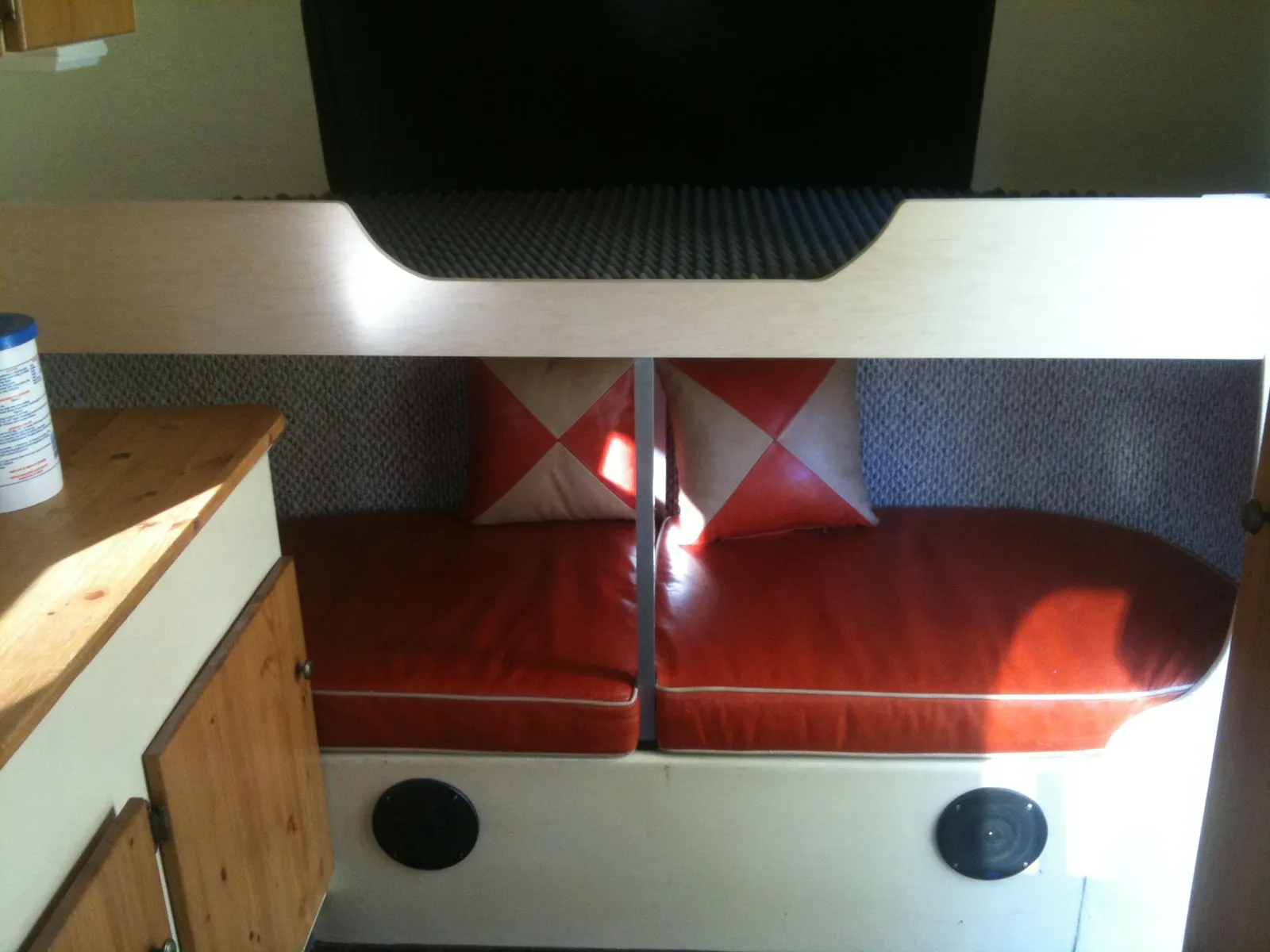 A red upholstered bench seat and wood trim inside the trailer.